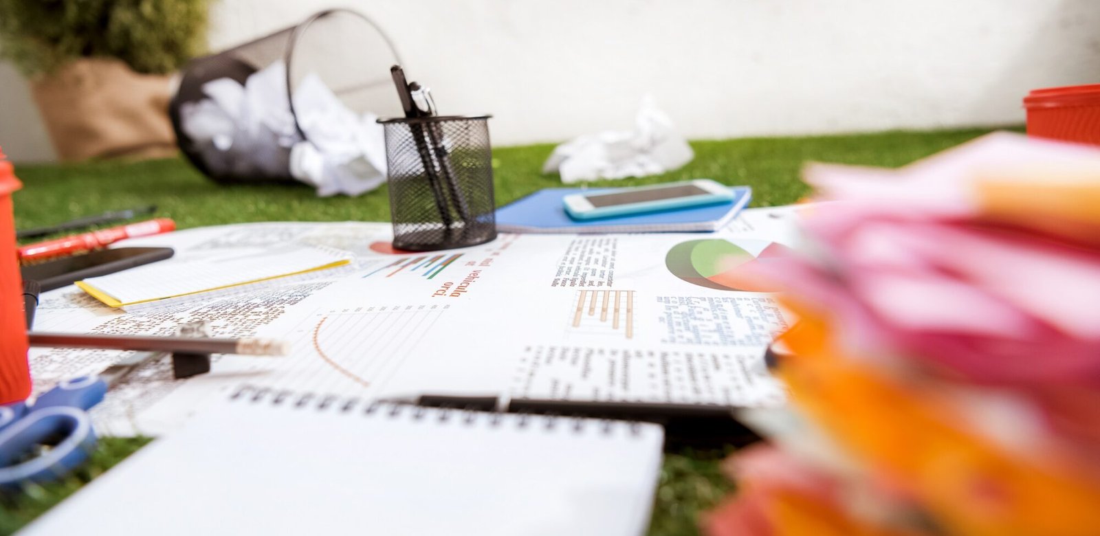 The Evolution of University LMS: From Basic Portals to Interactive Platforms heap of business objects and office supplies laying on green grass carpet at office, business